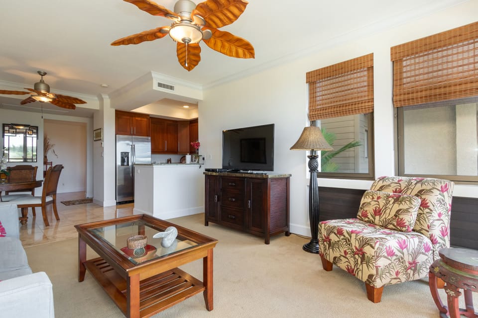 Relax in your island-inspired living space with tropical ceiling fans, bamboo shades, and a comfortable seating area perfect for unwinding after beach adventures.