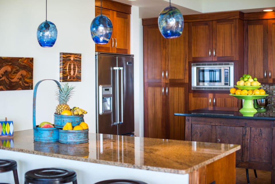 Kitchen with Bar Stools and fridge.
