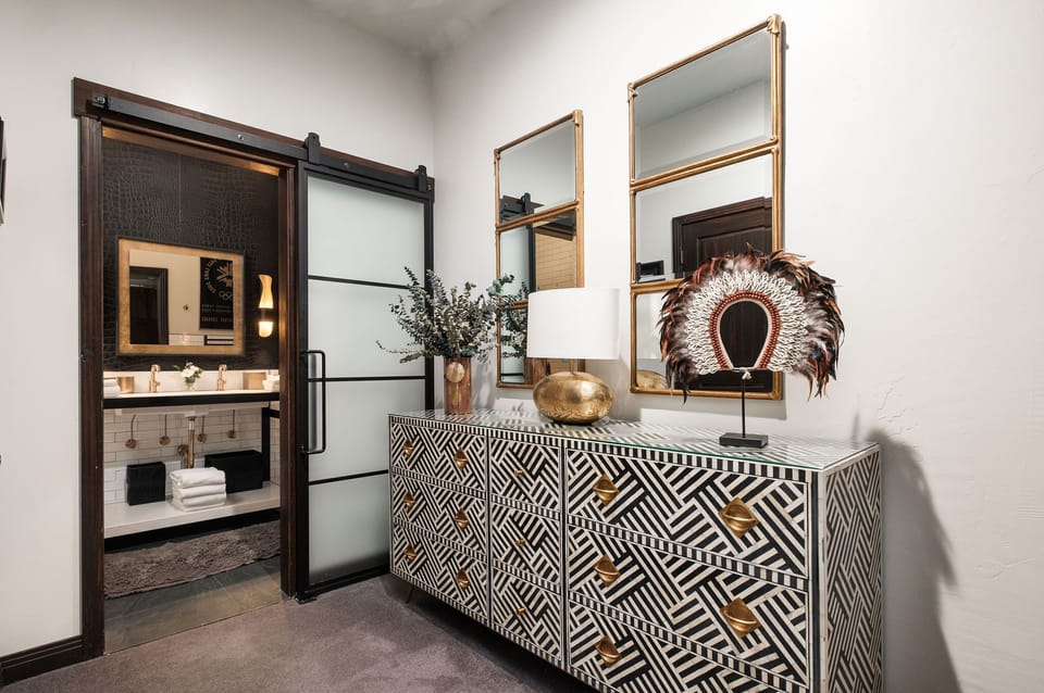 The main room with black and white dresser and stylish decor with gold accents.