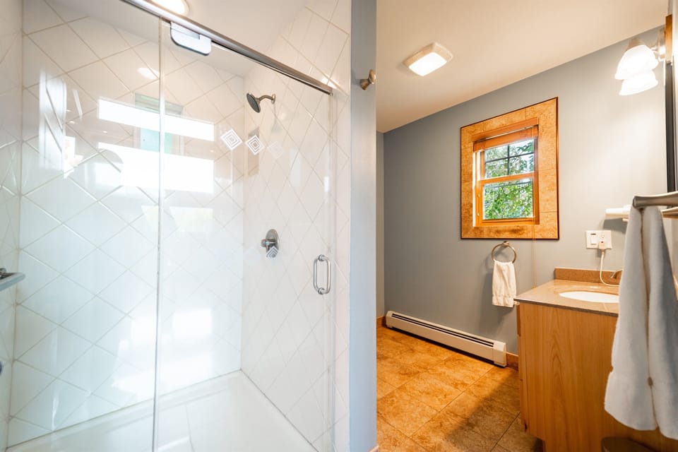 The main floor bathroom features a large 4x4 custom-tiled walk-in shower