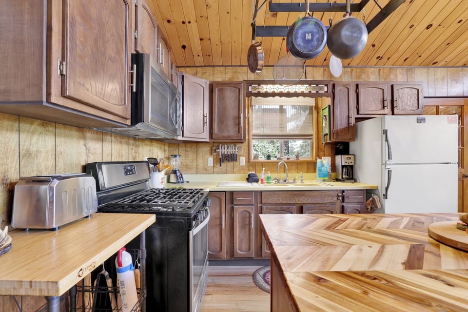 Fully equipped cabin kitchen with ample cabinetry, stove, fridge, microwave, and coffee maker—perfect for cooking meals, morning coffee, and feeling right at home on your stay.