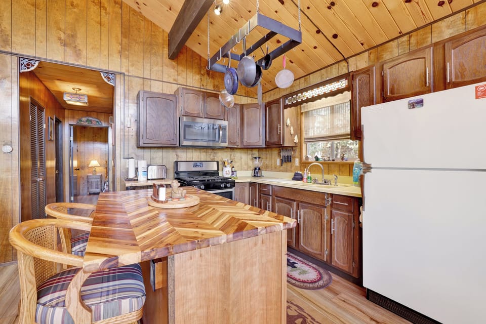 Fully equipped cabin kitchen with ample cabinetry, stove, fridge, microwave, and coffee maker—perfect for cooking meals, morning coffee, and feeling right at home on your stay.