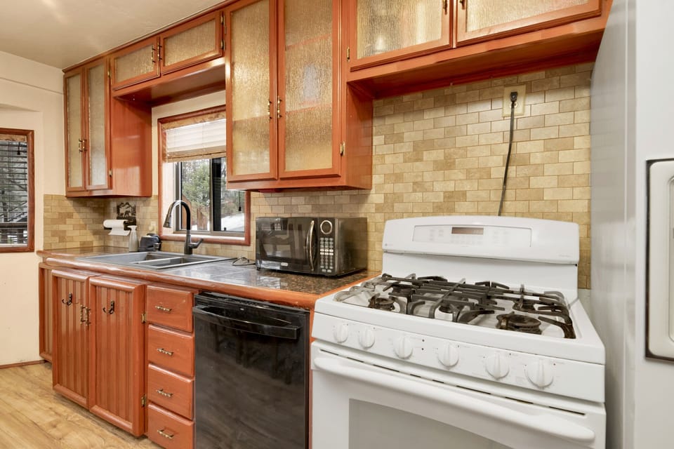 Fully equipped cabin kitchen with ample cabinetry, stove, fridge, microwave, and coffee maker—perfect for cooking meals, morning coffee, and feeling right at home on your stay.