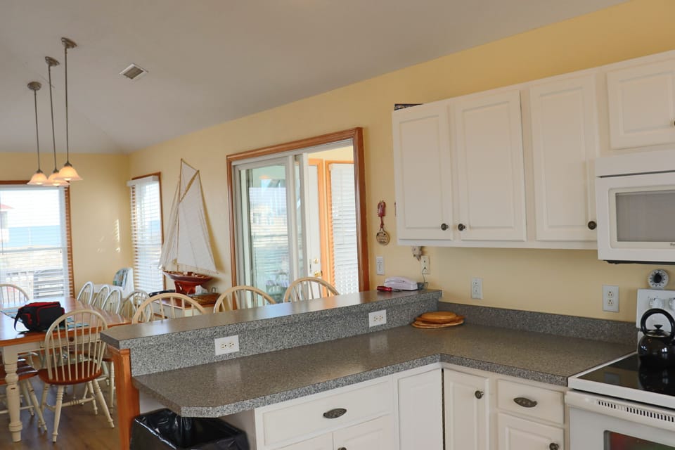 Kitchen looking at the island seating and blue ocean. - Kitchen looking at the island seating and blue ocean at Playing Hooky vacation rental, Carova Beach 4x4 Northern Outer Banks NC