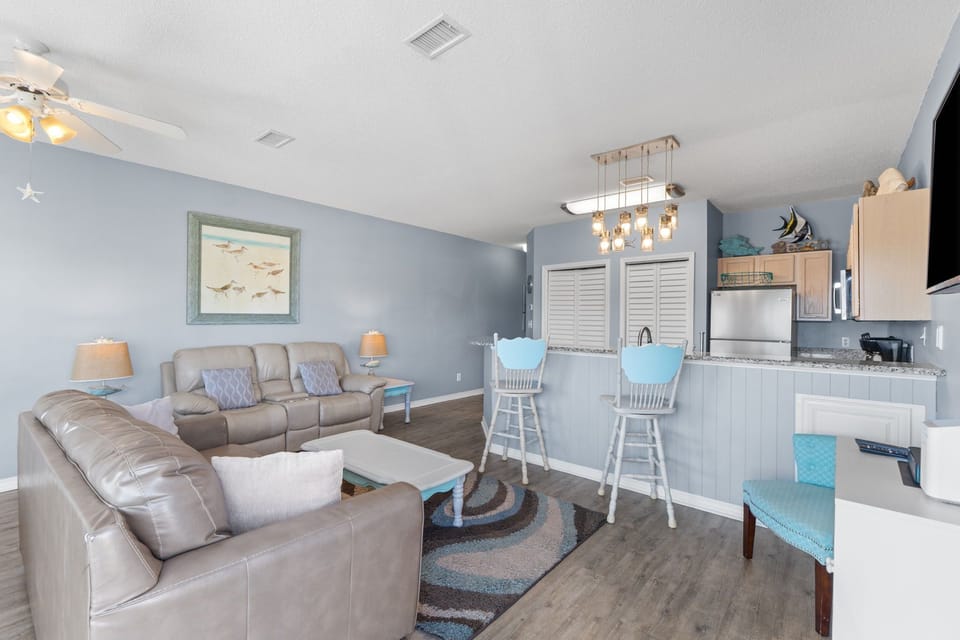 Relax in your coastal-inspired living room with comfortable leather seating and ocean-themed decor that welcomes you home.
