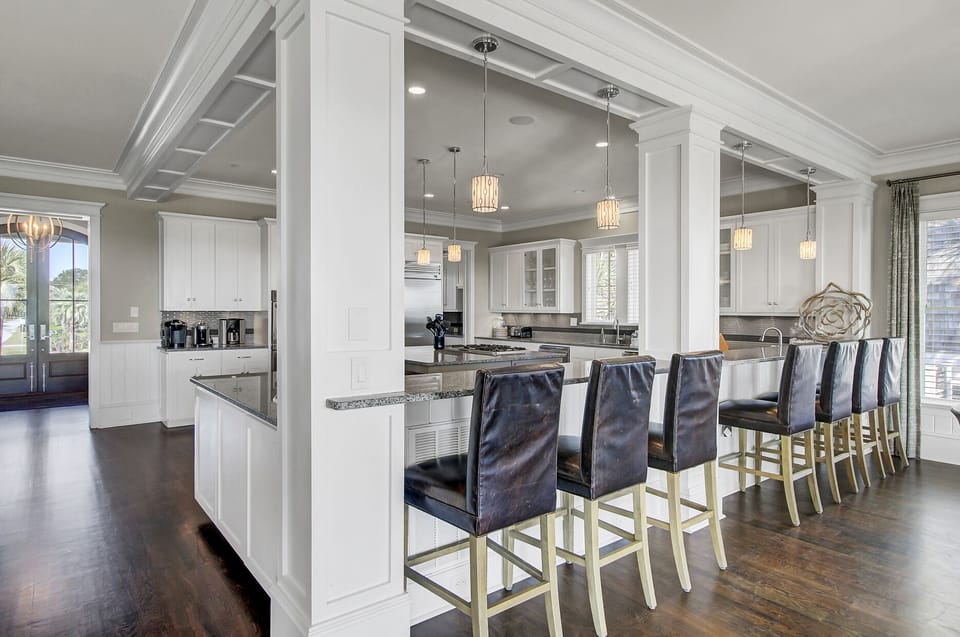 Large kitchen features an island and a wrap-around counter with 7 barstool seats.
