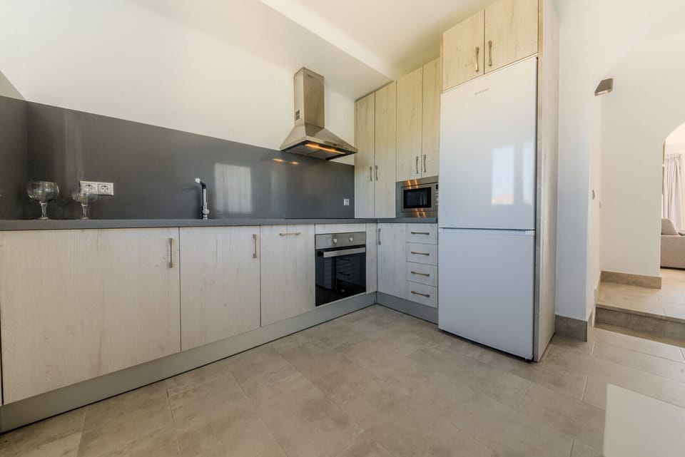 Countertop with oven and microwave, and refrigerator of the Kitchen of Villa Fuente del Gallo in Villas Flamenco Beach in Conil