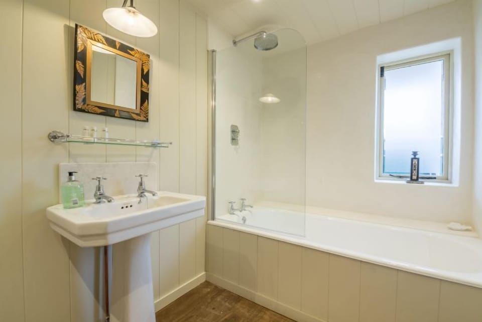 Ground floor: Family bathroom with bath with waterfall shower over