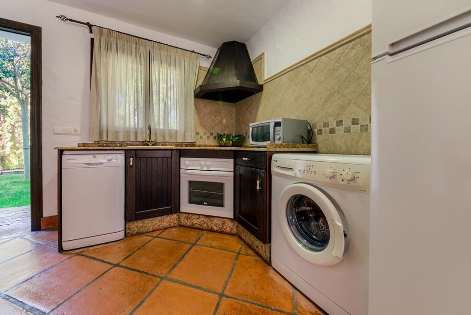 Fridge, oven, washing machine, microwave and countertop of Hierbabuena apartment kitchen in Hacienda Roche Viejo in Conil