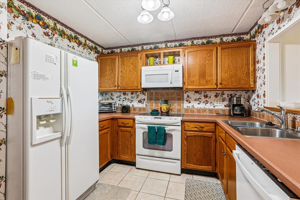 - Fully equipped kitchen with oak cabinets and white appliances  
- Decorative backsplash and counter space for meal prep  
- Ideal setup for cooking fresh dishes after beach days 
