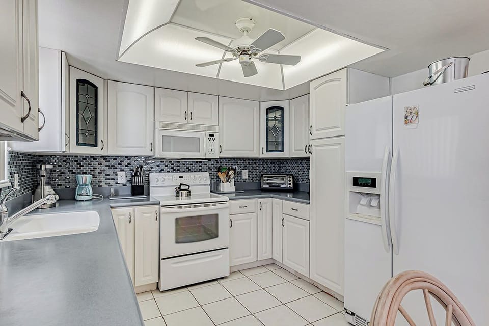 Your fully equipped kitchen features modern appliances and stylish tile backsplash for preparing meals during your stay.