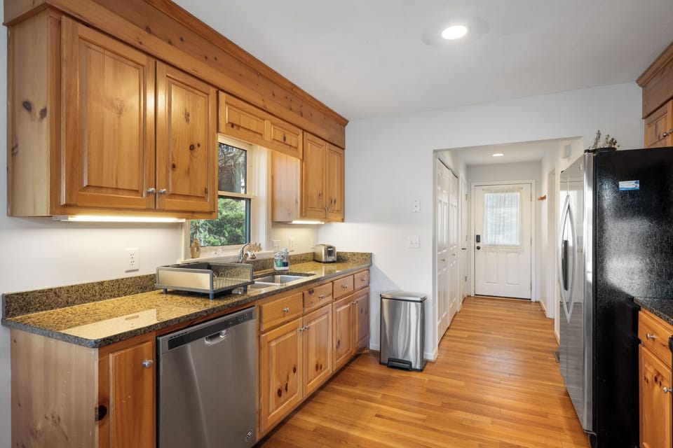 Your fully equipped kitchen features warm wood cabinets, granite counters, and modern appliances for preparing memorable meals during your stay.