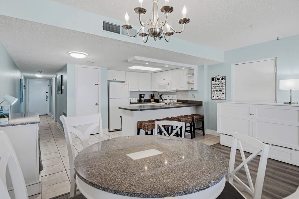 Gather around the spacious kitchen with granite countertops and breakfast bar, where mornings feel bright and breezy. Fresh white cabinetry and modern appliances make meal prep a pleasure in your coastal retreat.