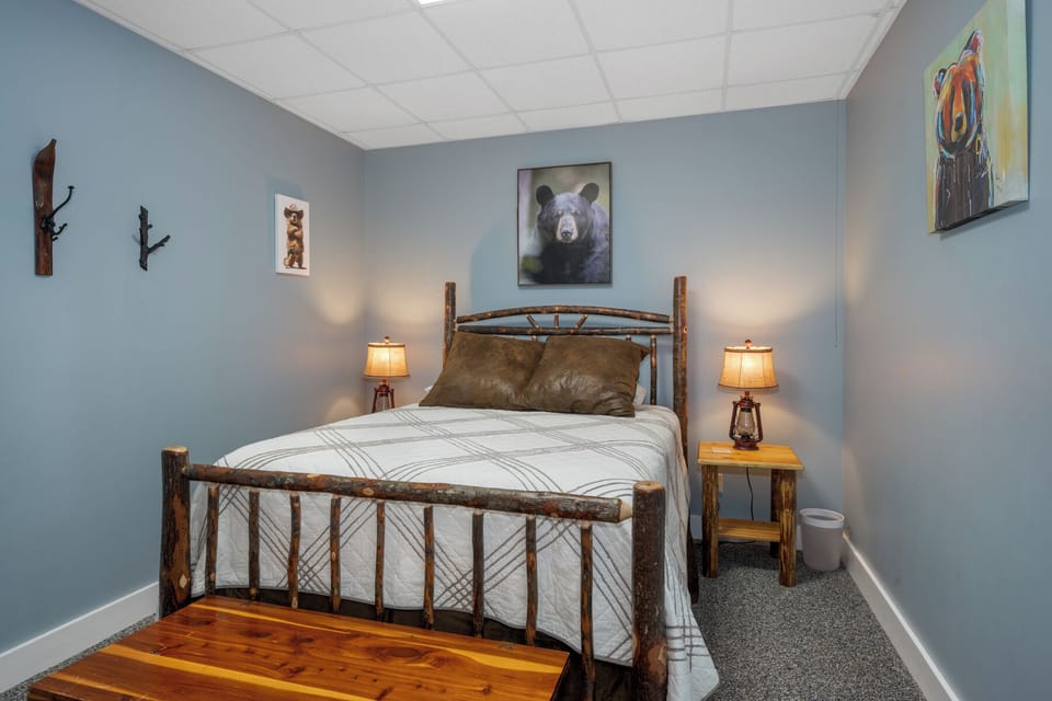 Cozy rustic bedroom with charming log bed frame and wildlife art creates your perfect mountain retreat sanctuary.