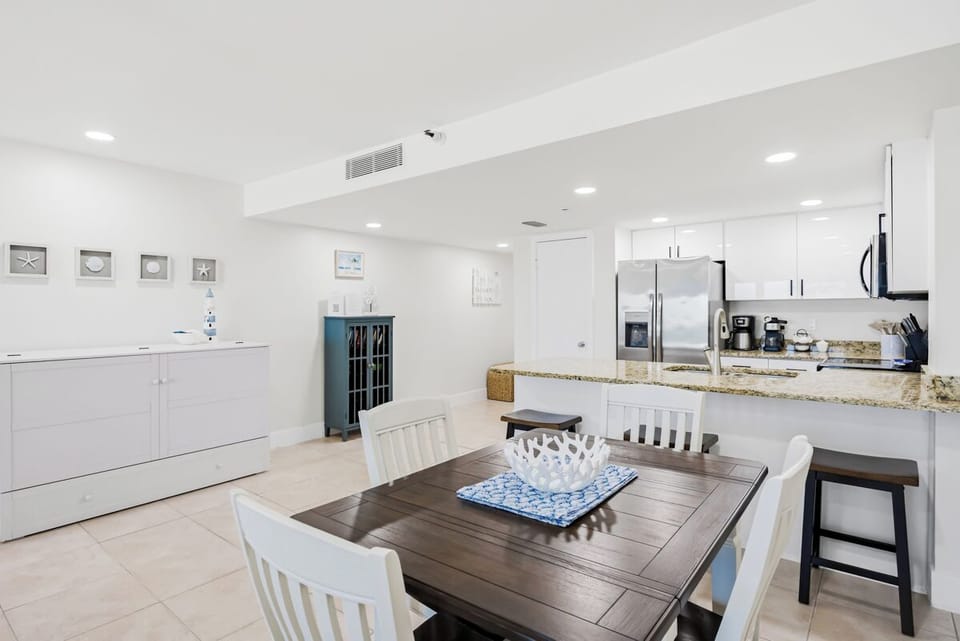 Your spacious kitchen flows seamlessly into the dining area, where coastal decor and granite counters create the perfect space for cooking and gathering.