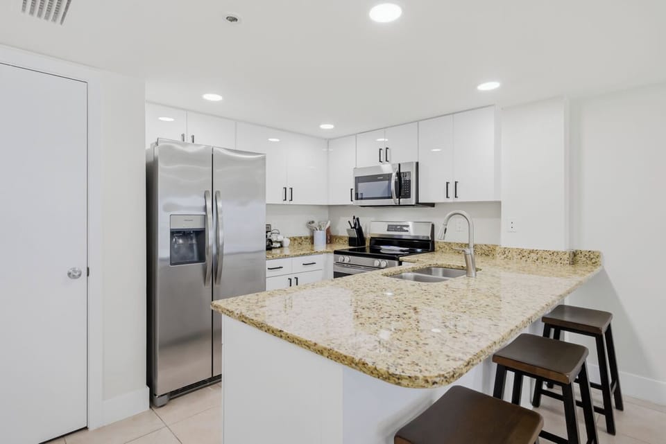 Your fully equipped kitchen features granite countertops, stainless steel appliances, and a breakfast bar perfect for morning coffee.