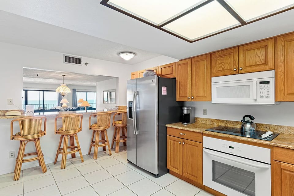 Your spacious kitchen flows seamlessly into the dining area, featuring warm wood cabinetry and modern appliances for effortless meal preparation.