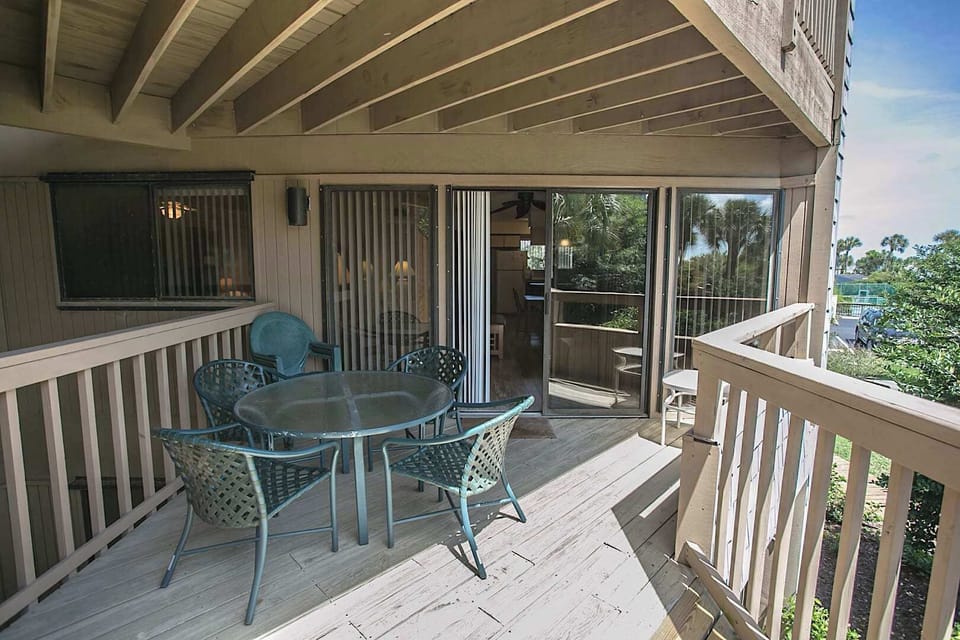 - Outdoor patio with round table and chairs for enjoying meals in the shade
- Sliding glass doors connect directly to the living space for easy access
- Surrounded by beautiful greenery providing a relaxing and private retreat