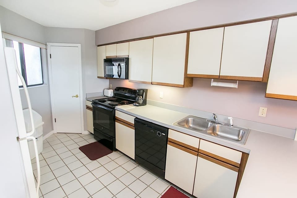 - Fully equipped kitchen with black appliances, dishwasher, and plenty of counter space
- Includes coffee maker, microwave, and essentials for easy meal prep at home
- Bright, clean design makes cooking and cleanup convenient during your stay