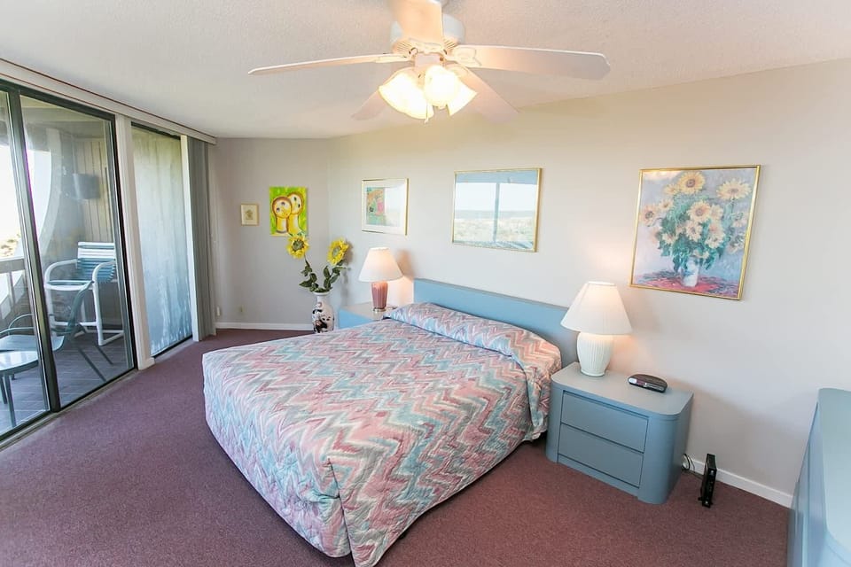 - Spacious bedroom with king bed and soft pastel bedding for a calming stay
- Large windows and sliding doors fill the space with natural light and views
- Direct balcony access lets you wake up to the sounds and sights of the ocean