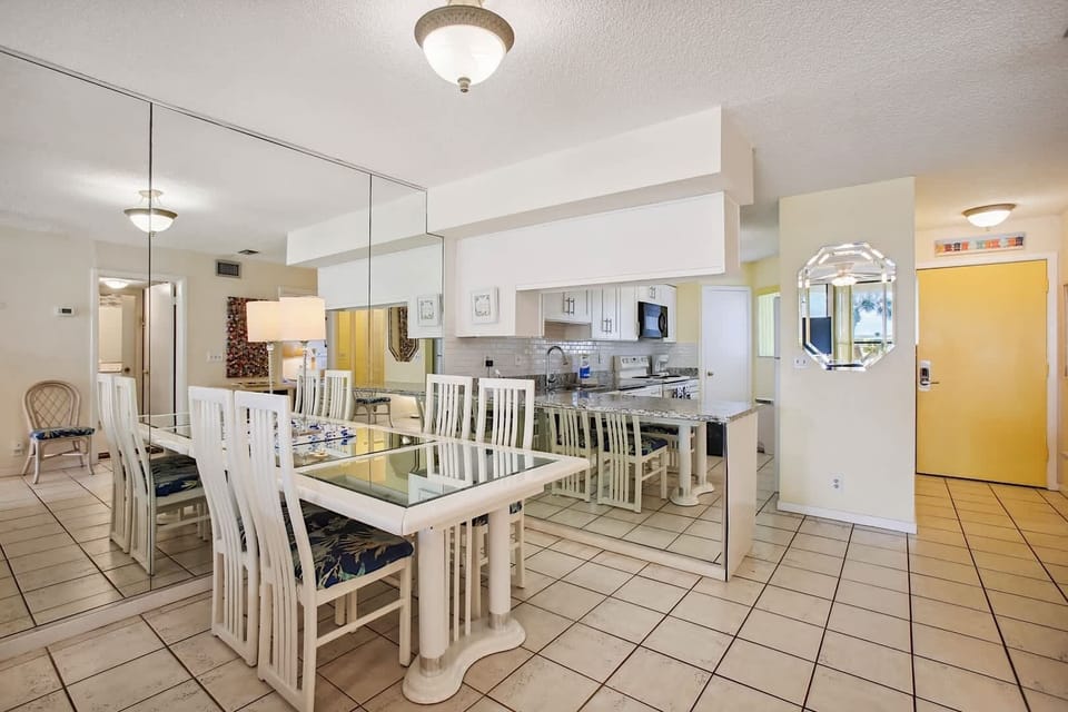 - Spacious dining area with mirrored wall that brightens and opens the room
- Glass top table with elegant high back chairs adds a coastal modern touch
- Conveniently located next to the kitchen for seamless entertaining
