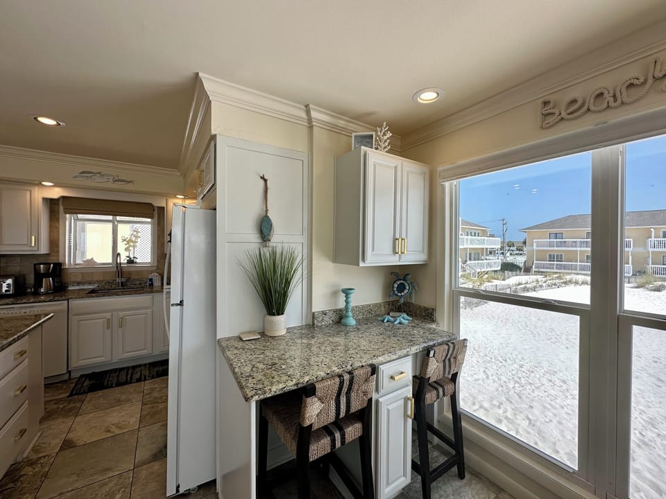 Wake up to stunning beach views right from your kitchen! Sip morning coffee at this charming breakfast bar while watching the sandy shoreline unfold.