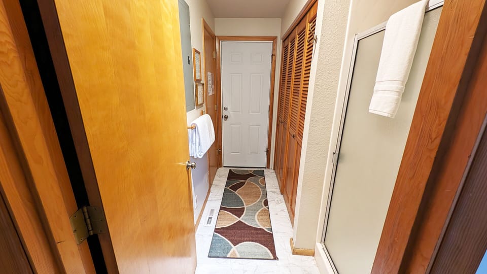 The hall houses a shower/ half bath and laundry closet