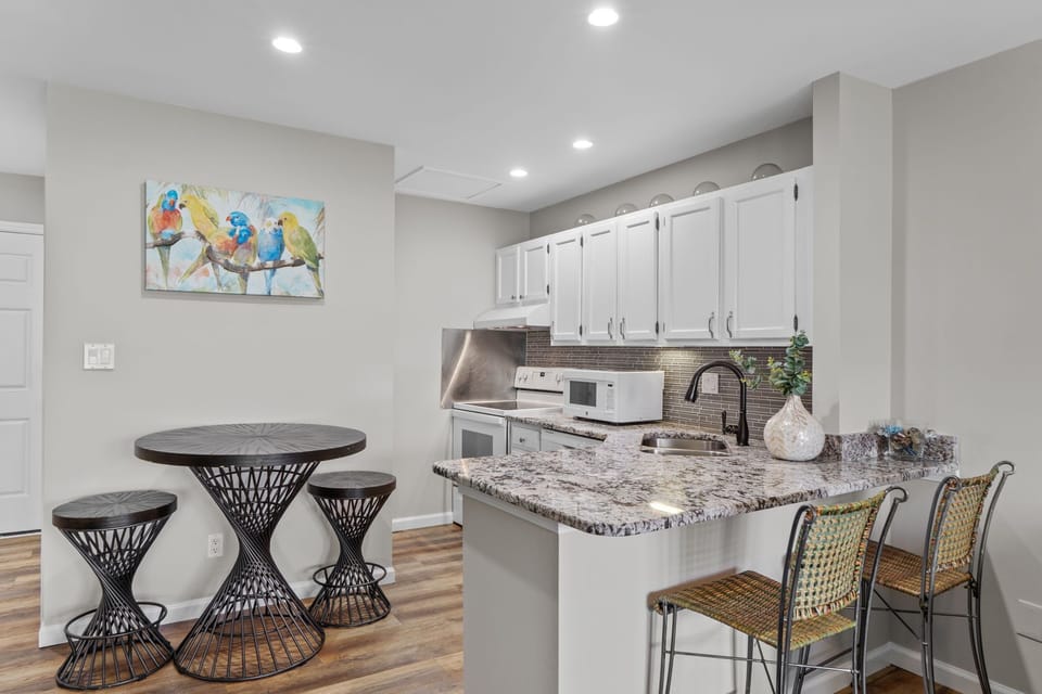 Your fully equipped kitchen features granite countertops, modern appliances, and a breakfast bar perfect for morning coffee or casual meals together.