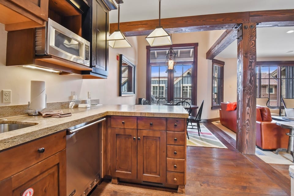 Your mountain retreat's fully-equipped kitchen features warm wood cabinetry and granite counters, perfect for preparing meals in this cozy space.