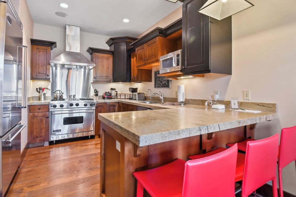 Your gourmet kitchen awaits with granite counters, professional-grade stainless appliances, and a breakfast bar perfect for morning coffee conversations.