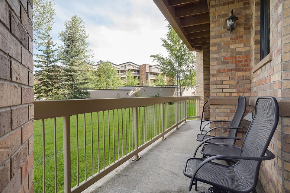 Relax on your private balcony overlooking peaceful green grounds, perfect for morning coffee or evening reflection.