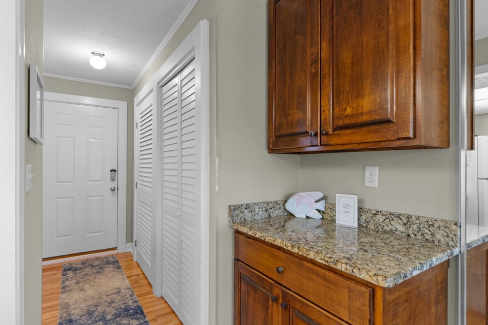 Your private entrance welcomes you into a bright kitchenette with granite counters, warm wood cabinetry, and plenty of storage to make you feel right at home.