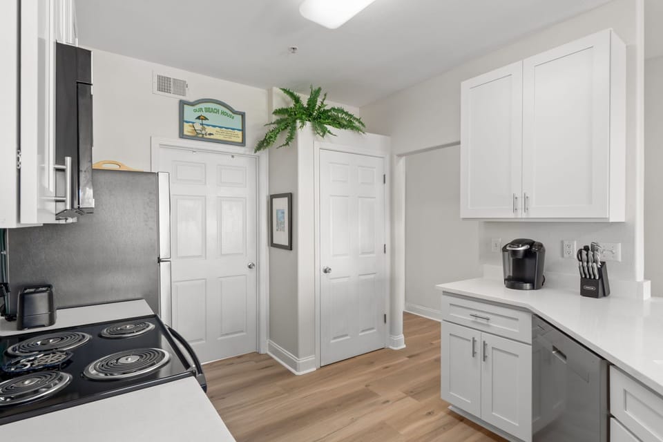 Your bright kitchen features white cabinets, modern appliances, and a cozy coffee station—perfect for starting your mornings right.