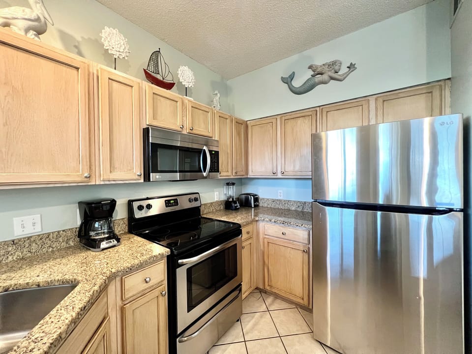 Your fully equipped kitchen features granite countertops, stainless steel appliances, and charming coastal decor to inspire your culinary adventures.