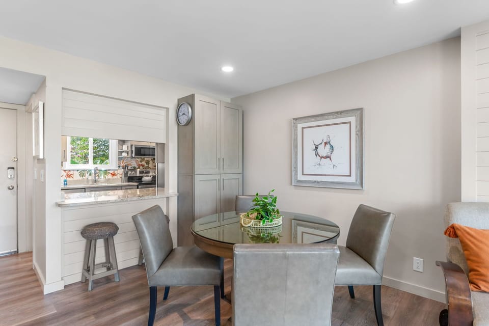 Gather around your dining table with garden views streaming through the pass-through window to the kitchen, where modern coastal style meets everyday comfort.