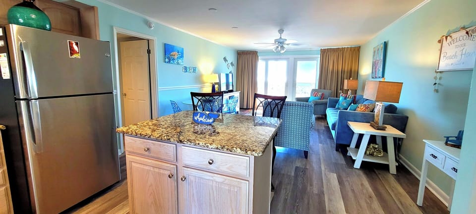 Step into your bright beachside retreat where coastal blues and granite counters create the perfect backdrop for memorable meals and relaxing evenings.