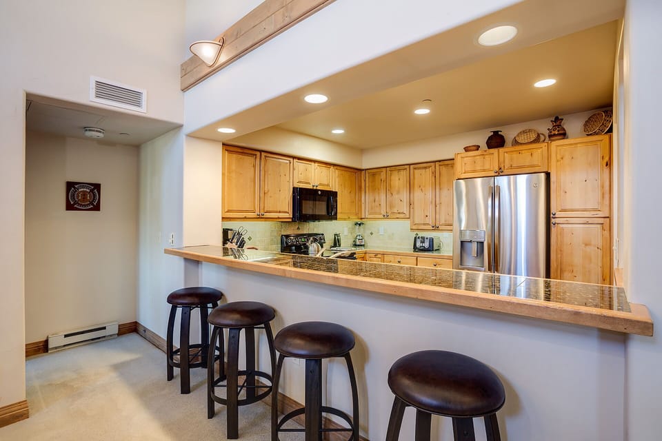 Your spacious kitchen features granite counters, stainless steel appliances, and a breakfast bar perfect for morning coffee or casual dining.