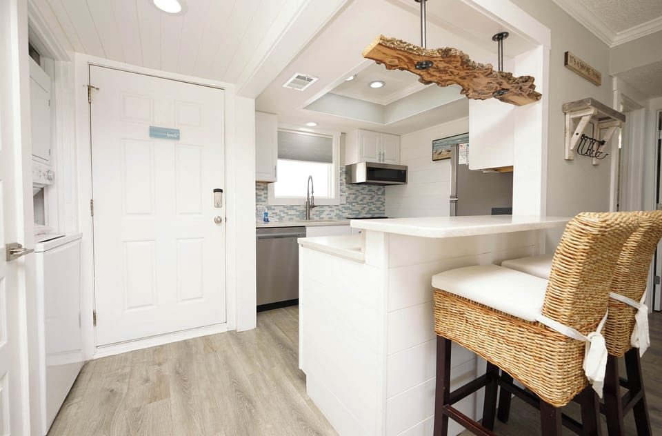 Discover your bright, modern kitchen with sleek white cabinets and coastal touches—perfect for preparing meals with ocean-inspired style.