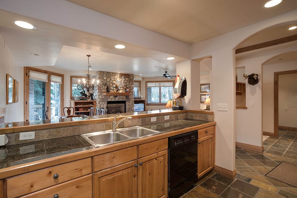 Your spacious kitchen features granite counters, double sinks, and opens to a cozy living area with stone fireplace—perfect for cooking and entertaining.