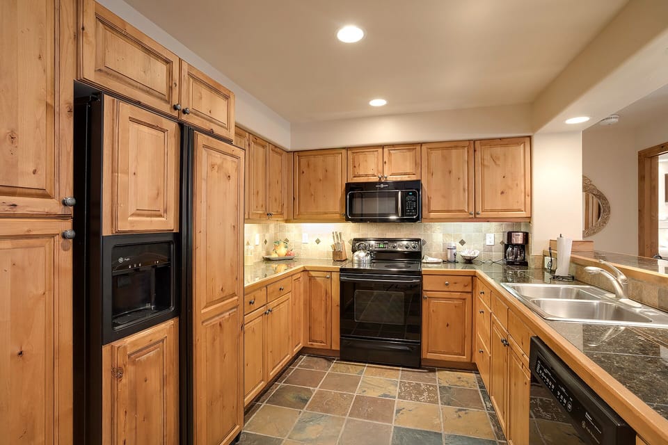 Your spacious kitchen features warm wood cabinets, granite counters, and full appliances—perfect for preparing memorable meals during your stay.