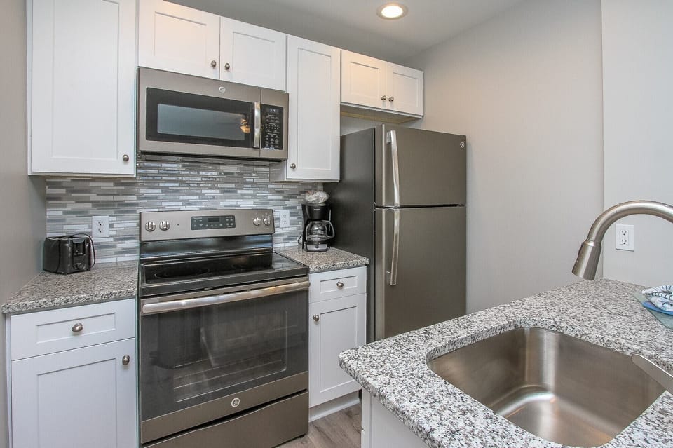 Ocean Dunes 107 - Kitchen - The newly renovated Kitchen / Dining Area features all stainless appliances, granite counters and beautiful glass  backsplash  .