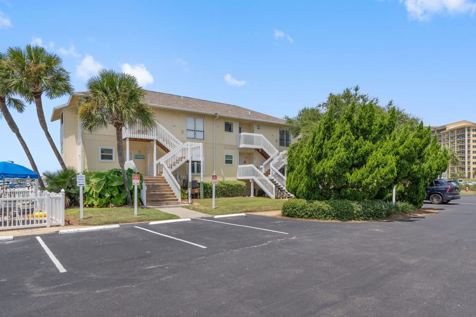 Beachside vacation complex with tropical landscaping and convenient parking near coastal high-rises.