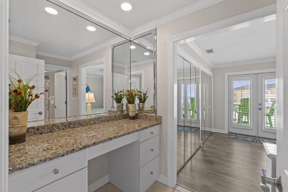 Your spacious vanity area offers granite countertops and mirrored wardrobes, creating an elegant space to start your day.