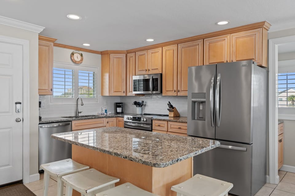 Your fully equipped kitchen features granite countertops, stainless steel appliances, and a breakfast bar perfect for morning coffee or meal prep.