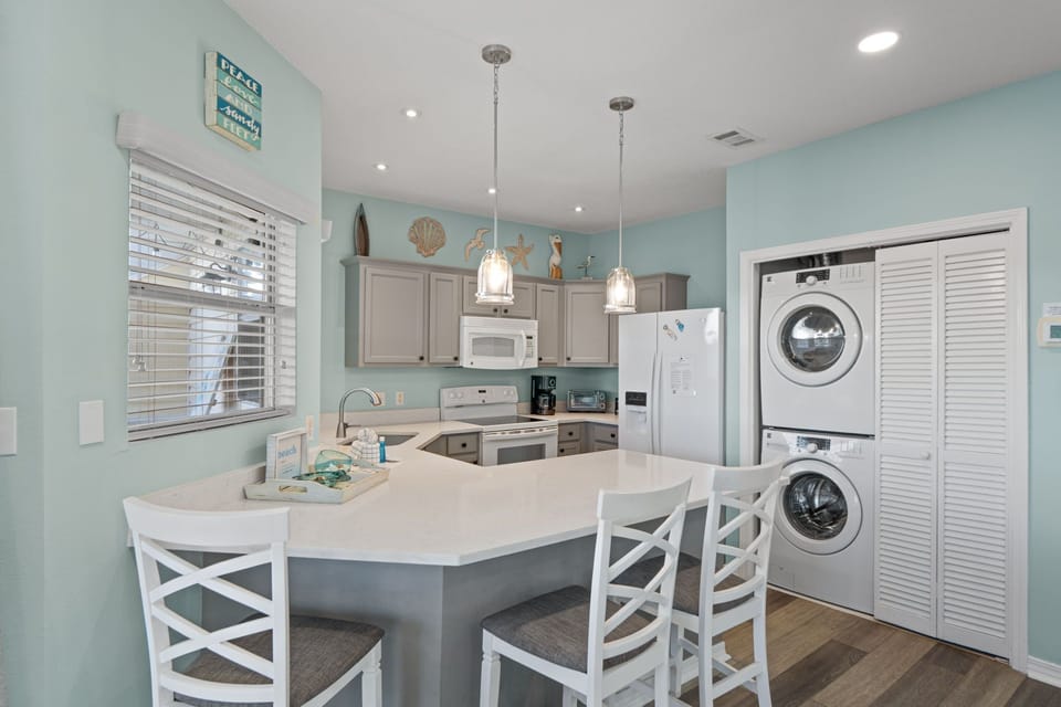 Cook meals in your bright coastal kitchen with modern appliances and convenient in-unit washer and dryer for ultimate comfort.