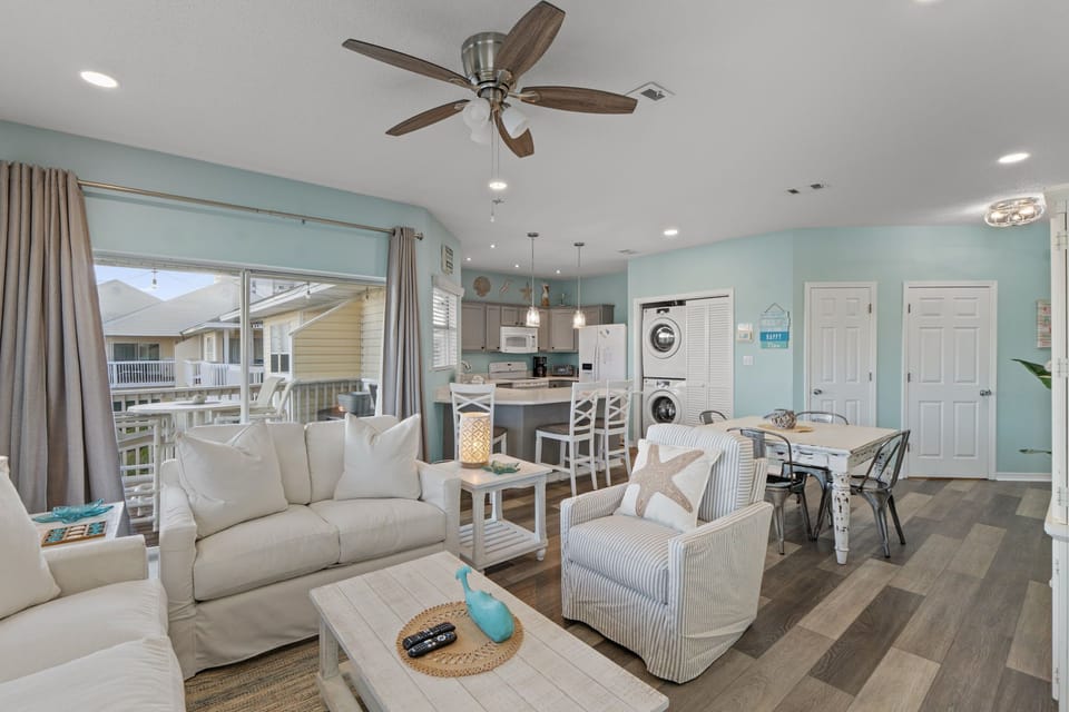 Relax in your bright open-concept space featuring coastal décor, full kitchen, and convenient in-unit laundry—perfect for your beach getaway.