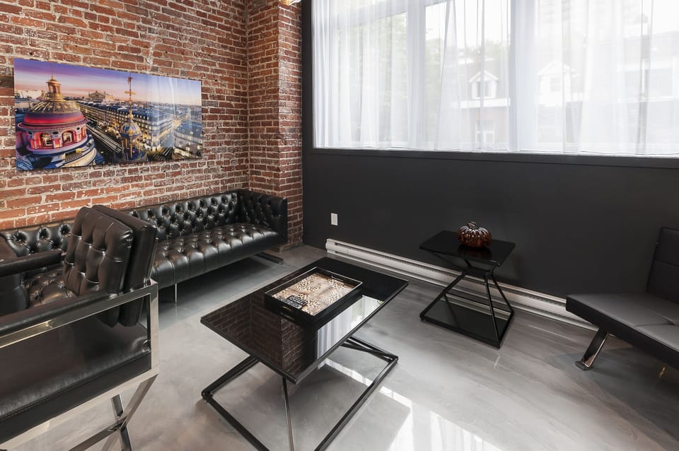 Bright living room with big windows. Nice brick wall 