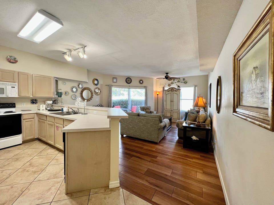 Your open-plan kitchen flows seamlessly into the cozy living space, where warm wood floors and thoughtful décor create the perfect home base.
