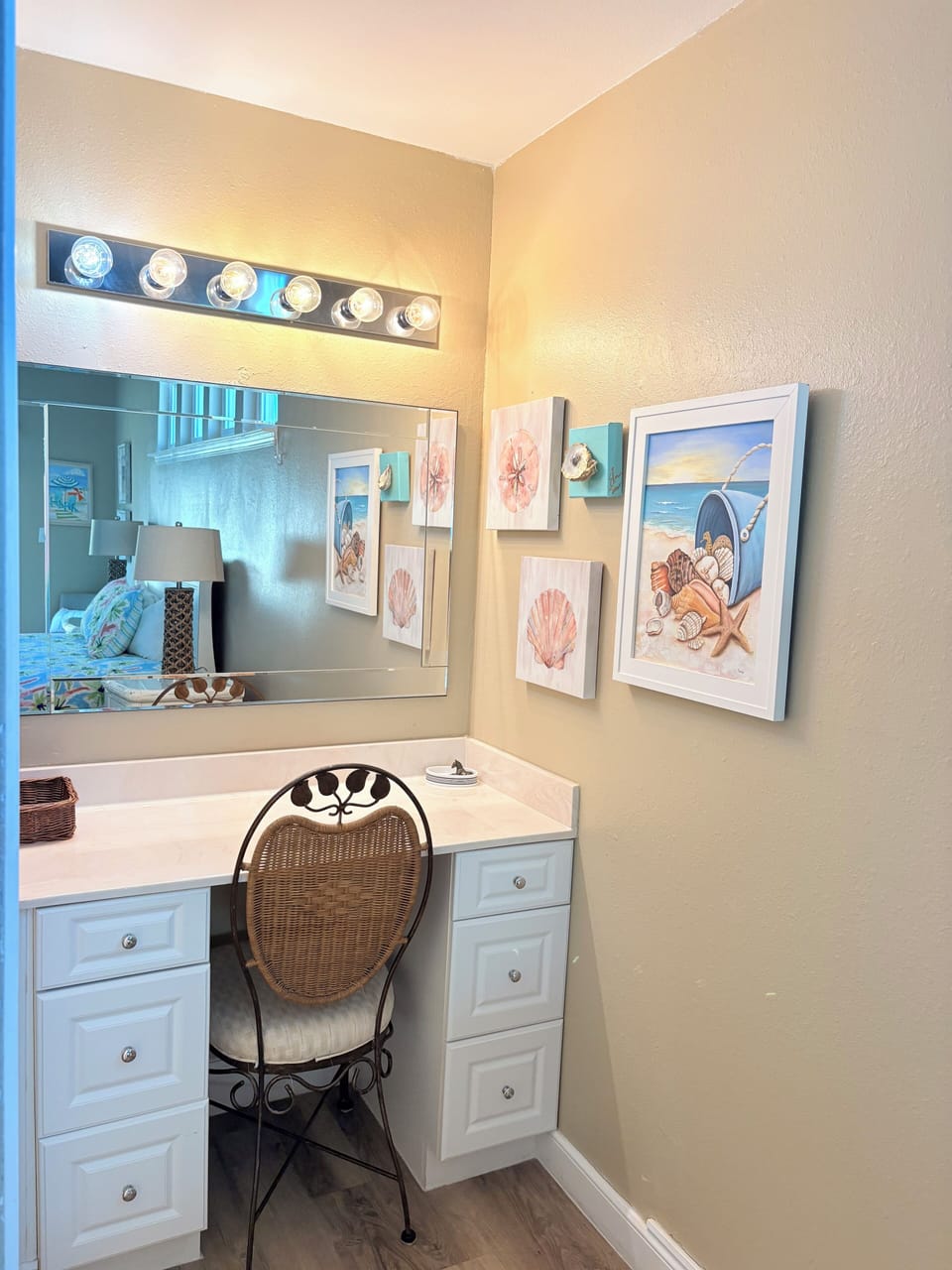 Relax in your charming coastal-themed bathroom featuring nautical artwork, Hollywood-style vanity lighting, and thoughtful beach decor that creates a spa-like retreat.