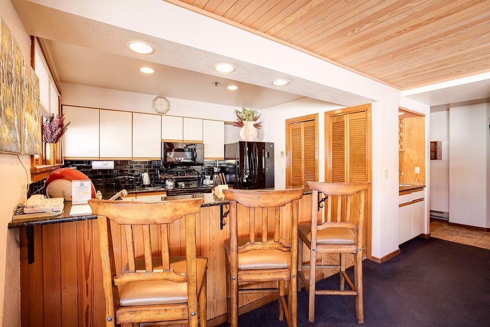 Your fully equipped kitchen invites culinary adventures with warm wood accents, granite counters, and a cozy breakfast bar.
